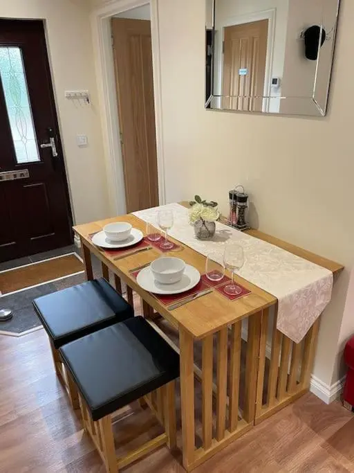 a wooden table with two chairs and wine glasses at The Apartment in Nairn
