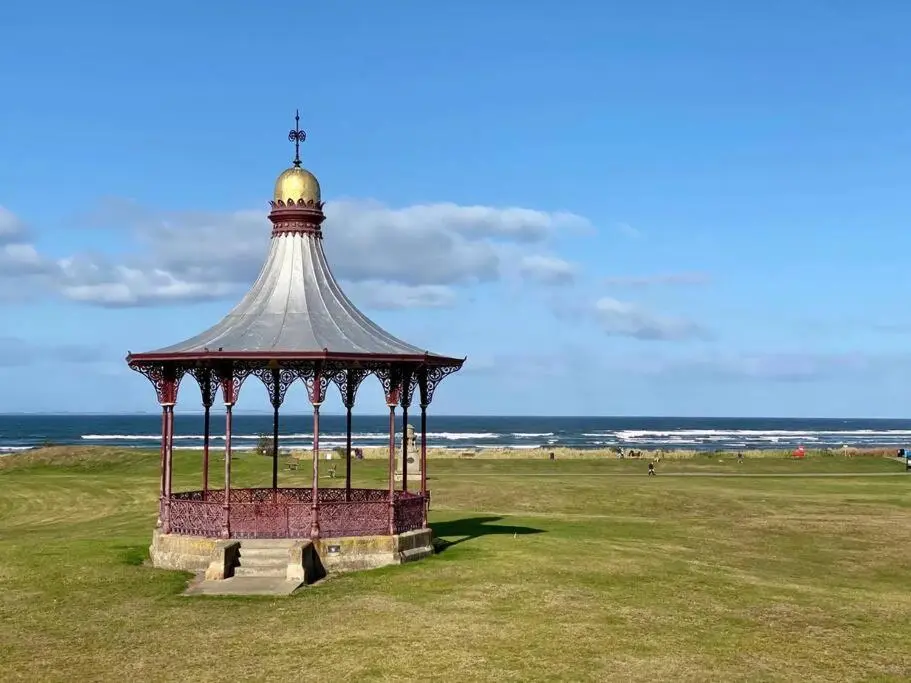 a gazebo in a field near the ocean at The Apartment in Nairn