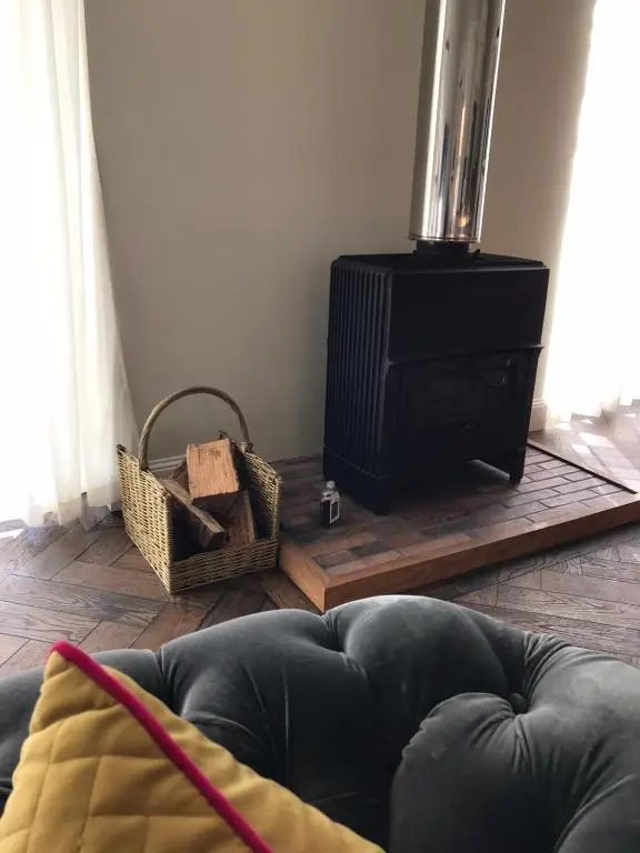 a living room with a couch and a stove at Gardeners cottage in Pitlochry