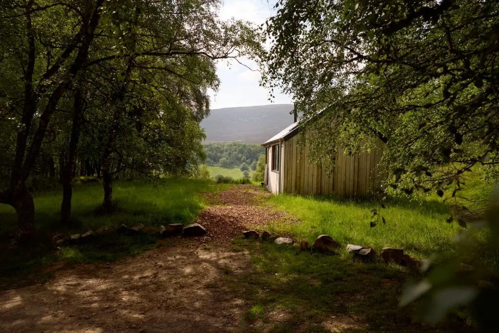 a dirt road next to a shed in a field at The Dell at Glenlivet in Glenlivet