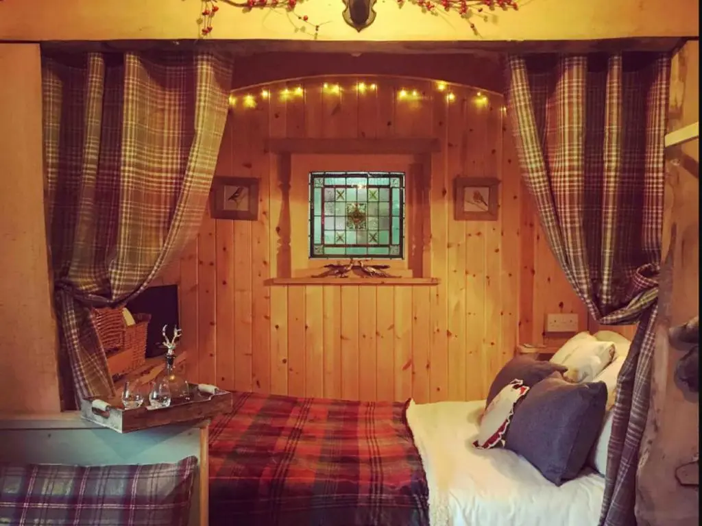 a bedroom with a bed and a window at Holiday Home Shepherds Hut by Interhome in Bearnock