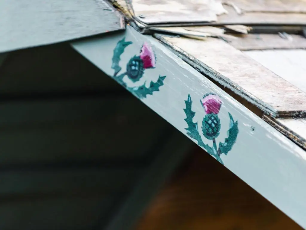 a close up of a wooden door with flowers on it at Holiday Home Shepherds Hut by Interhome in Bearnock