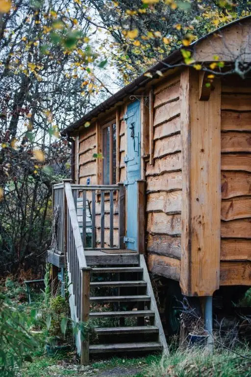 a wooden cabin with stairs leading to a door at Holiday Home Shepherds Hut by Interhome in Bearnock