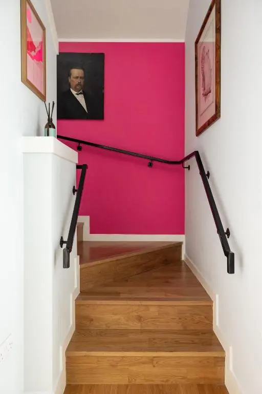 a pink wall in a hallway with a staircase at Number 2 Steading Cottage in Banchory