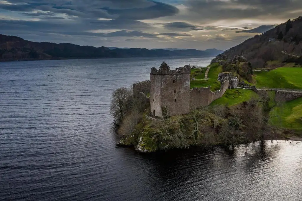 a castle on an island in a body of water at Loch Ness Hideaway Pod in Lewiston