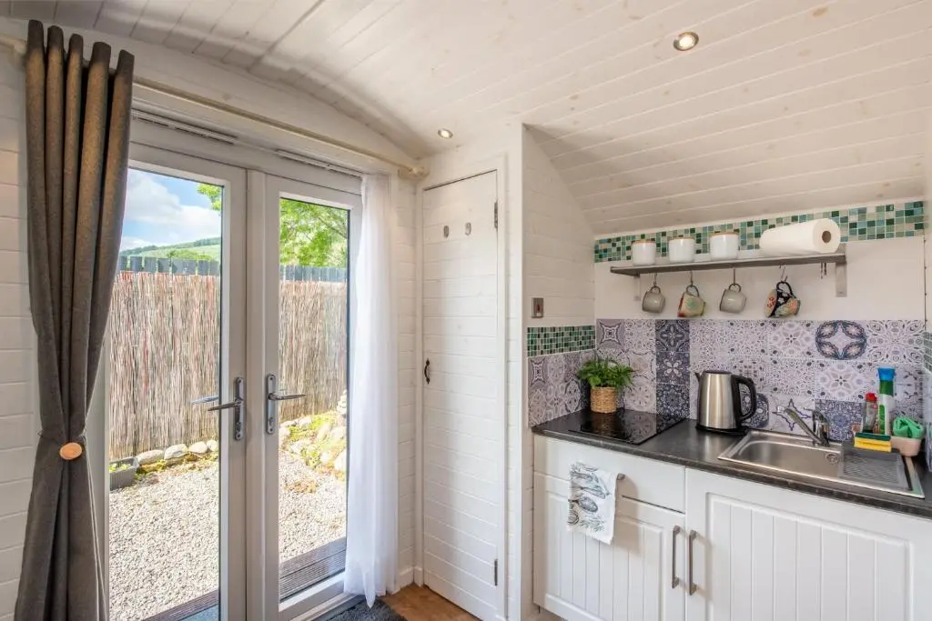 a kitchen with a sink and a window at Loch Ness Hideaway Pod in Lewiston