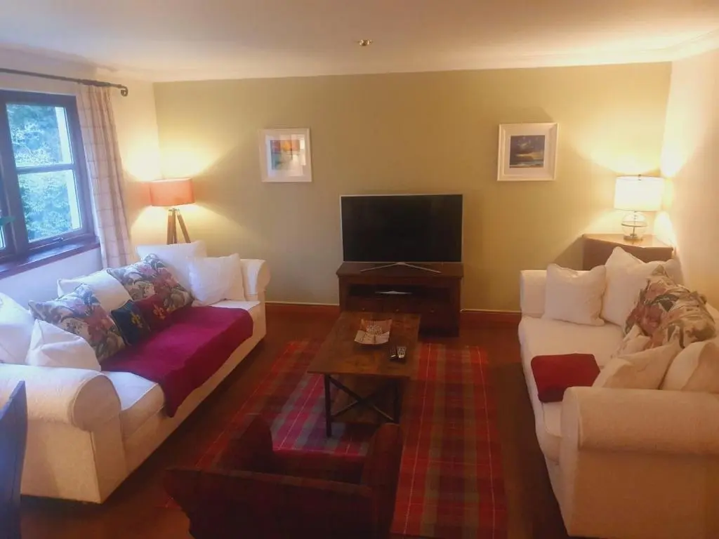 a living room with two couches and a tv at Apartment at Drummond Crescent in Inverness