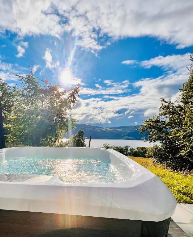 a jacuzzi tub with the sun in the sky at 1 Loch Ness Heights in Inverness