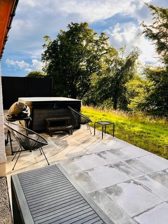 a patio with a piano and two chairs and a table at 1 Loch Ness Heights in Inverness