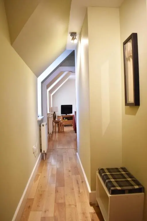 an attic hallway with a room with a table at The Ross 2 bedroom apartment in historic Abbey in Fort Augustus