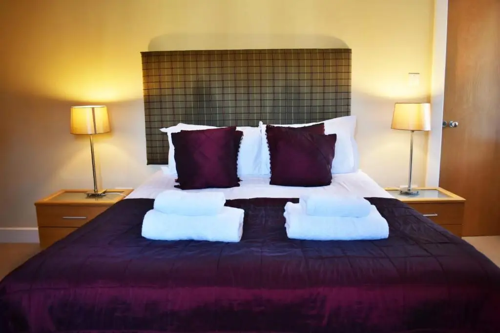 a bedroom with a large bed with two pillows at The Ross 2 bedroom apartment in historic Abbey in Fort Augustus