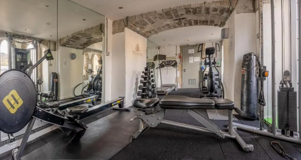 a gym with several tread machines in a room at Monastery apartment with Loch Ness view in Fort Augustus