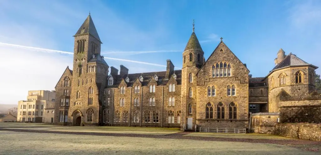 a large brick building with a tower on top at Monastery apartment with Loch Ness view in Fort Augustus