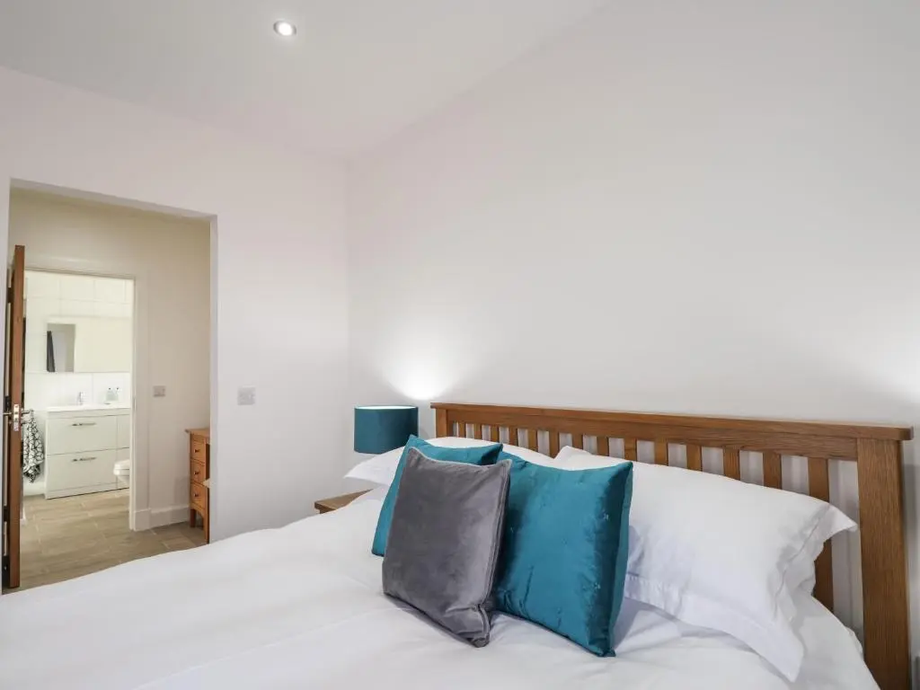 a bedroom with a white bed with blue pillows at Firthview in Nairn