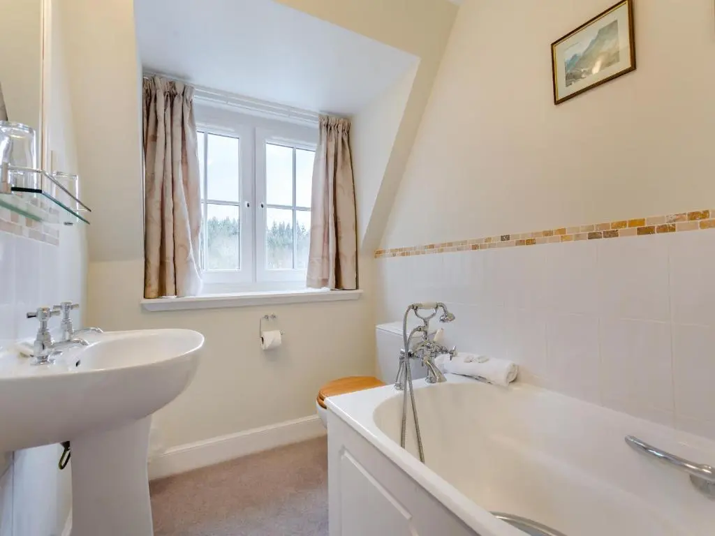 a bathroom with a sink and a bath tub at Cruives Lodge in Kiltarlty