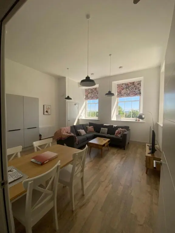 a living room with a couch and a table at Hiltula spacious premium apartment with beautiful views in Inverness