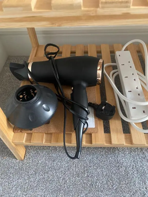 a hair dryer sitting on top of a wooden table at Hiltula spacious premium apartment with beautiful views in Inverness