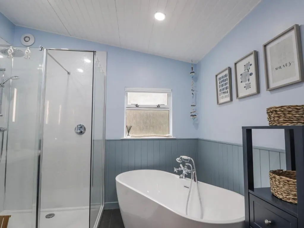 a bathroom with a tub and a glass shower at 20 South High Street in Portsoy