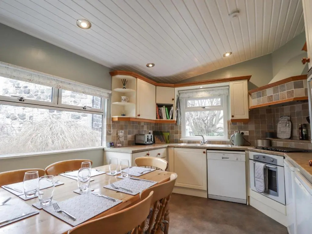 a kitchen with a table with wine glasses on it at 20 South High Street in Portsoy