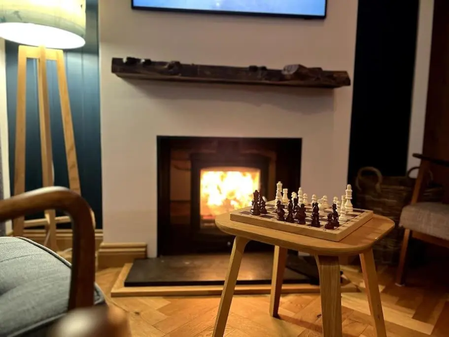 a chess board on a table in a living room with a fireplace at Osprey Hide in Forres