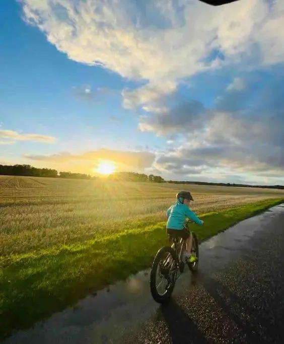 a young child riding a bike down a road at Osprey Hide in Forres