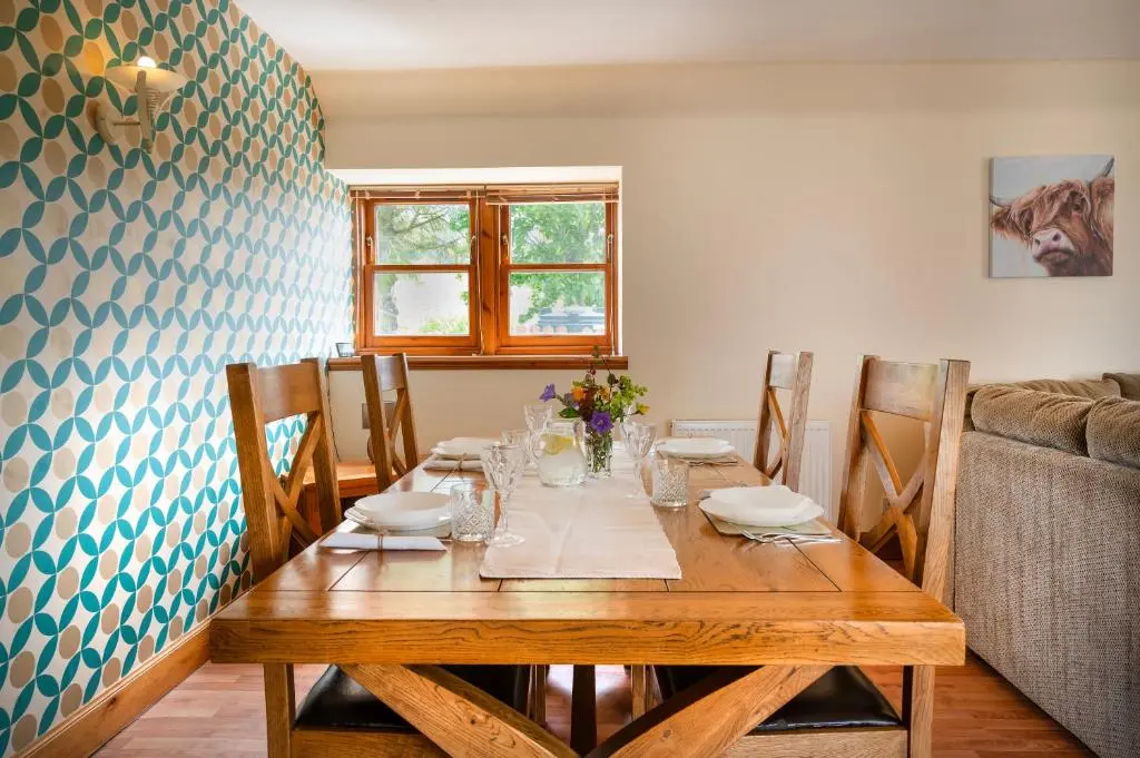 a wooden table in a dining room with a tableablish at Barclay\u2019s But n Ben in Alford