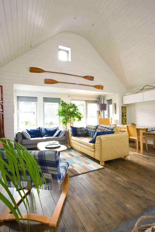 a living room with couches and a table at Driftwood Cottage, Findhorn Village in Forres