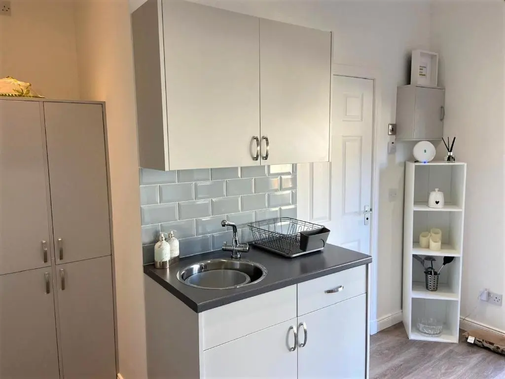 a kitchen with a sink and a refrigerator at Chalet on the Green - Self Contained with parking. in Inshes