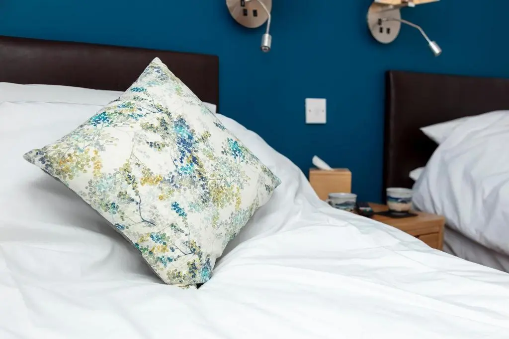 a white bed with a pillow on top of it at Lochbroom Lodge in Ullapool