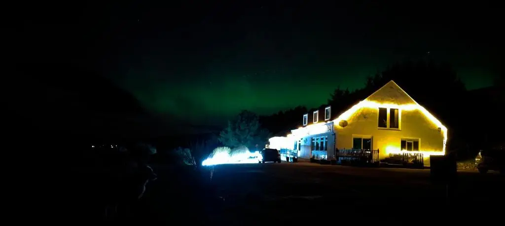 a house with a green light on it at night at Lochbroom Lodge in Ullapool