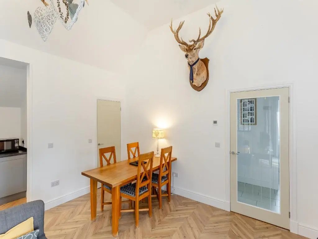 a dining room with a table and chairs at Old School House in Altnaharra