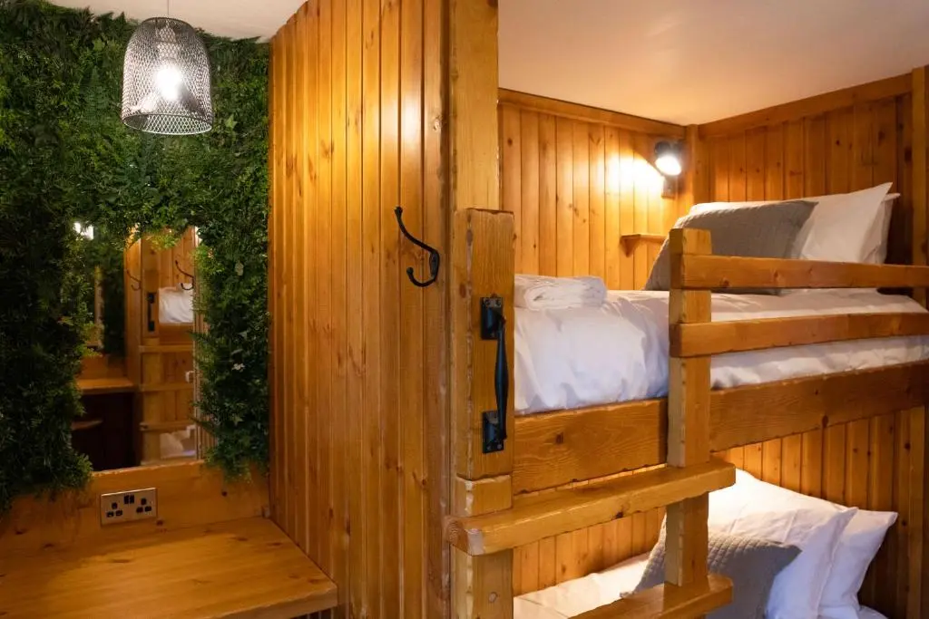 a room with two bunk beds and a mirror at The Wilds - Seasgair Lodges in Kingussie