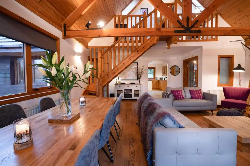 a living room with a large wooden table and chairs at The Wilds - Seasgair Lodges in Kingussie