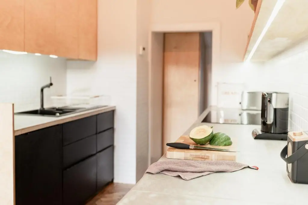 a kitchen with a counter top with a bowl of watermelon on a cutting board at The Dell of Abernethy - A Woodland hideaway in Nethy Bridge