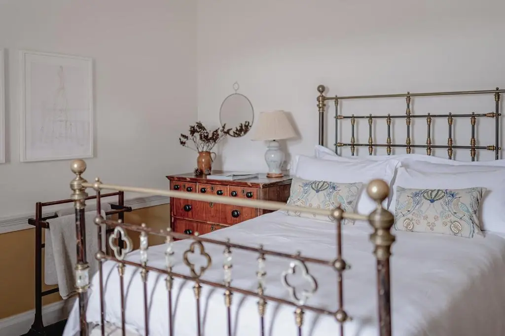 a bedroom with a bed and a table with a mirror at The Dell of Abernethy - A Woodland hideaway in Nethy Bridge