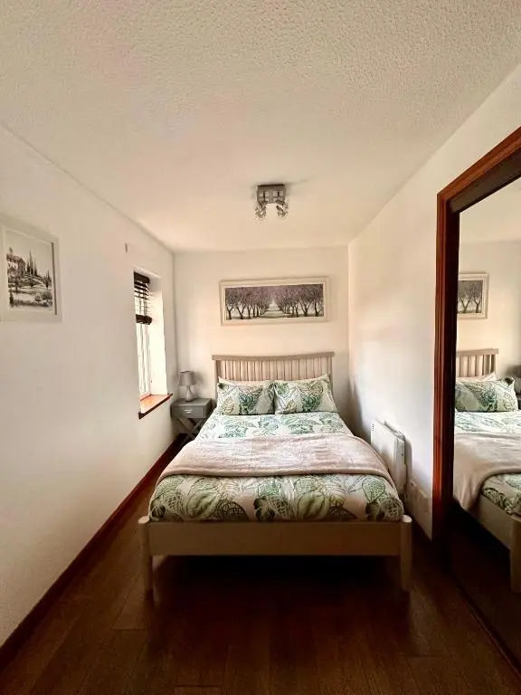 a bedroom with a bed and a mirror at Apartment with parking, close to the Raigmore hospital in Inverness