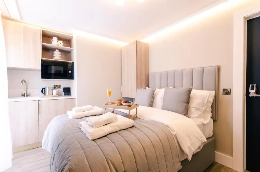 a bedroom with a large bed with towels on it at Sweeney Aviemore One in Aviemore