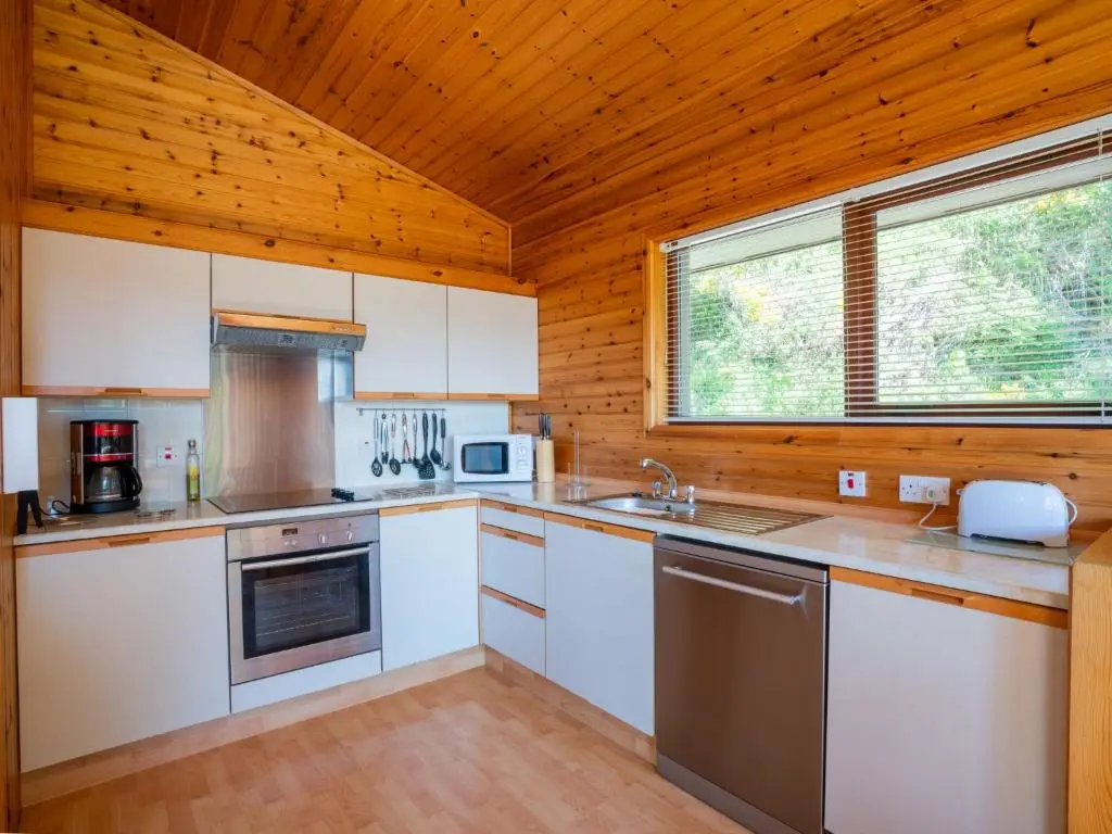 a kitchen with white appliances and a wooden ceiling at Holiday Home Achmony Number 9 by Interhome in Drumnadrochit