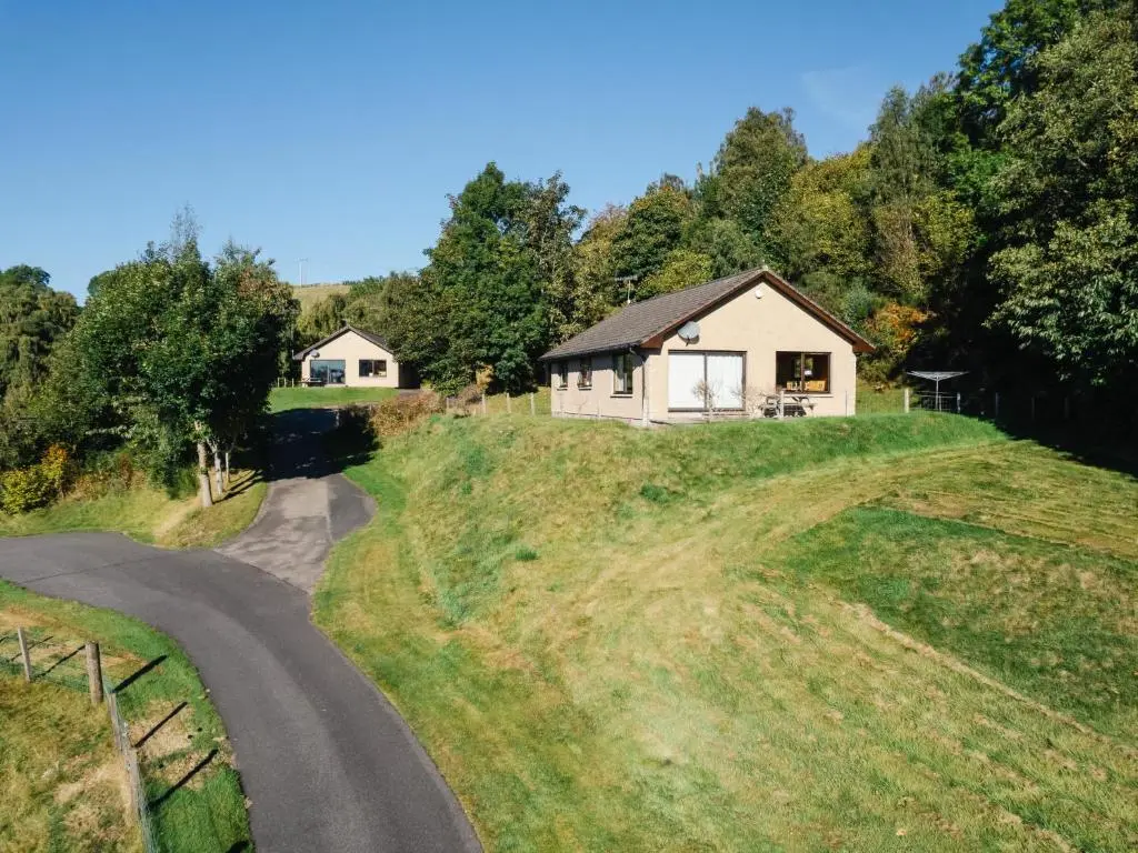a house on a hill next to a road at Holiday Home Achmony Number 9 by Interhome in Drumnadrochit