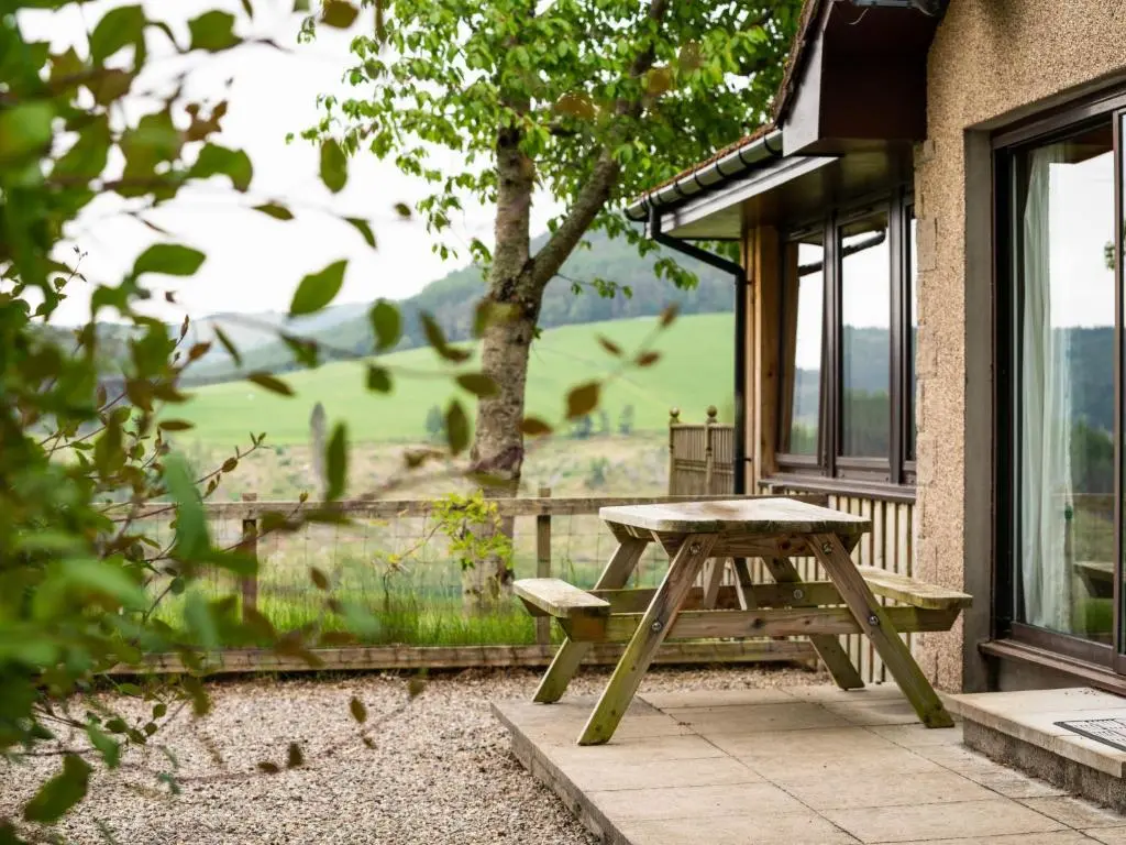 a picnic table in front of a building with a window at Holiday Home Achmony Number 8 by Interhome in Drumnadrochit