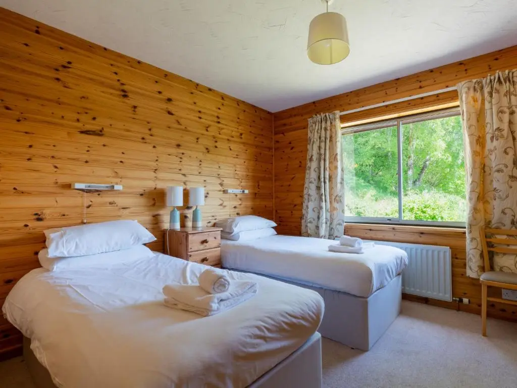 a bedroom with two beds and a window at Holiday Home Achmony Number 6 by Interhome in Drumnadrochit