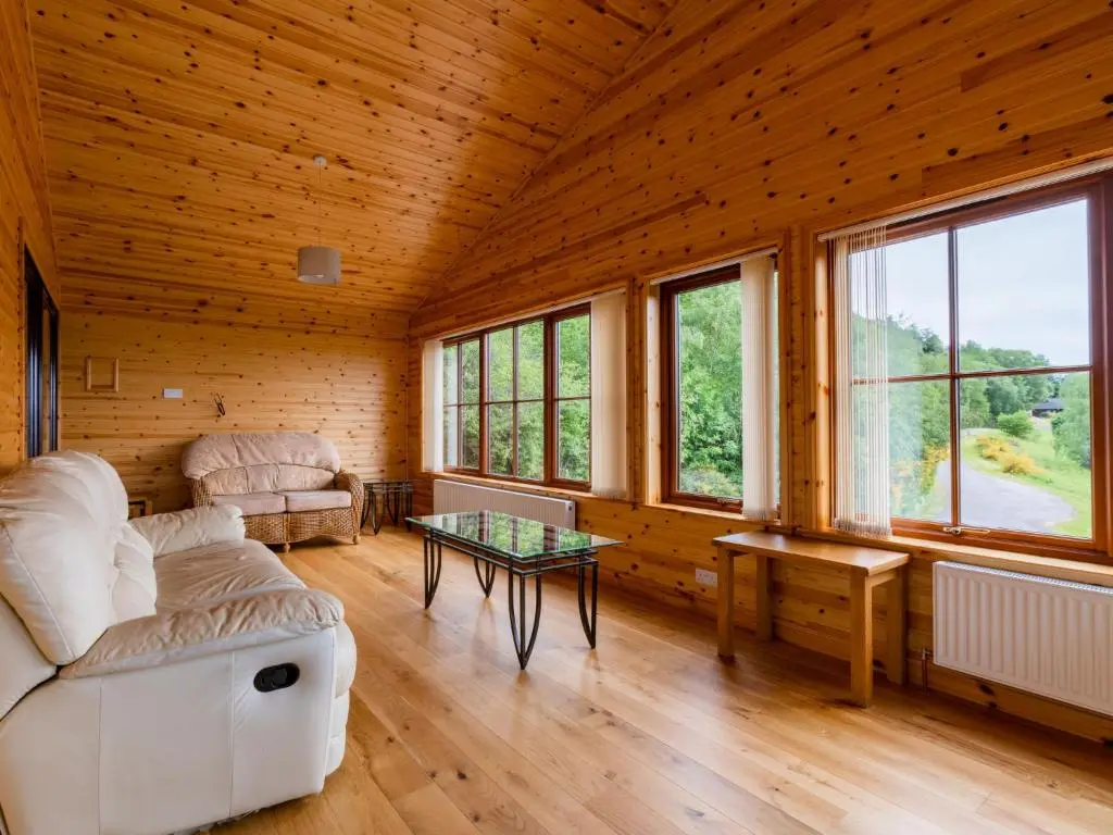 a living room with a couch and a table at Holiday Home Achmony Green by Interhome in Drumnadrochit
