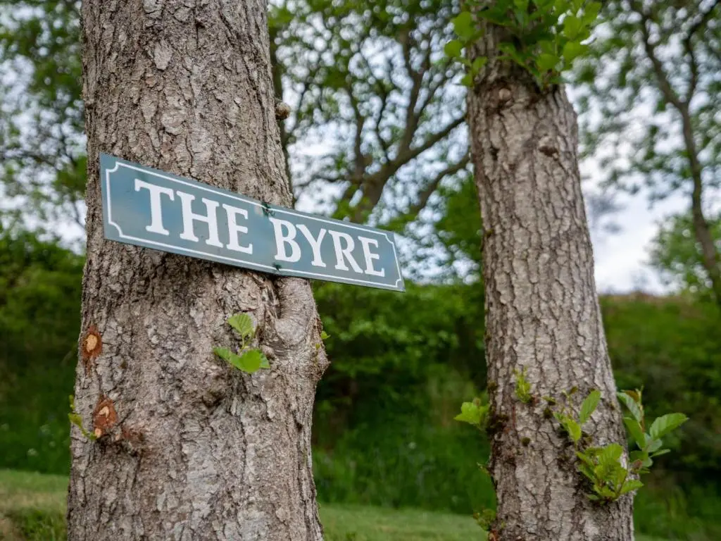 a street sign attached to a tree at Holiday Home Achmony Byre by Interhome in Drumnadrochit