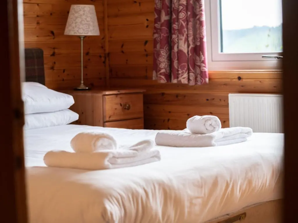 a bedroom with two beds with towels on them at Holiday Home Achmony Number 7 by Interhome in Drumnadrochit