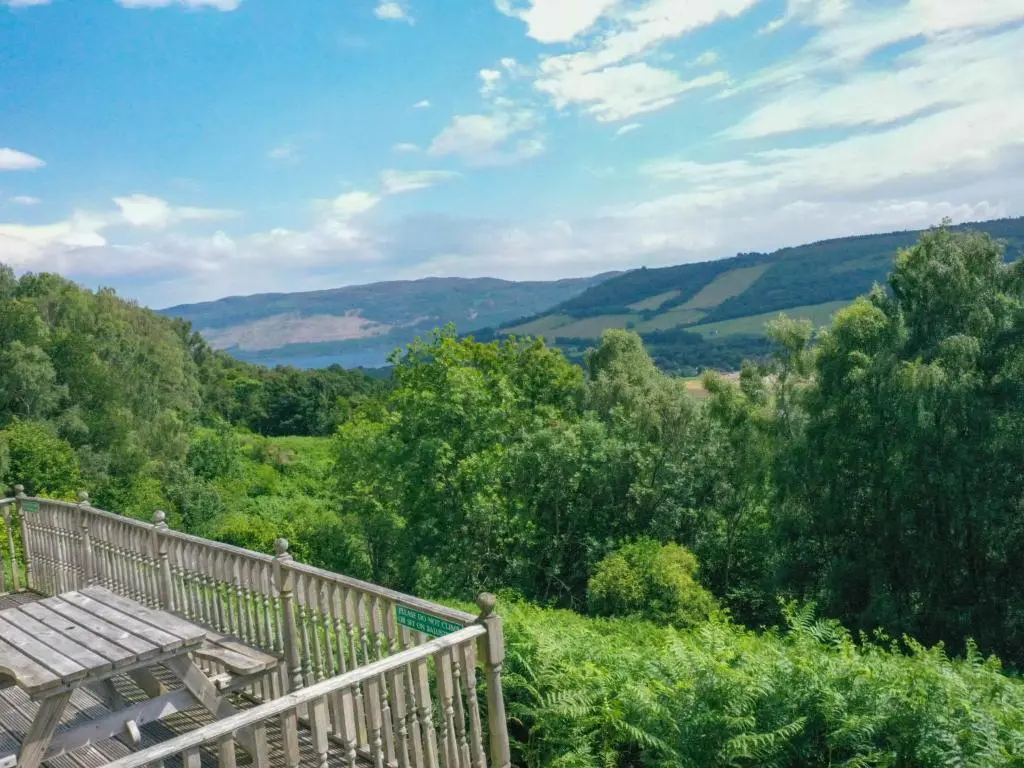 a deck with a table and a view of the mountains at Holiday Home Achmony Number 7 by Interhome in Drumnadrochit