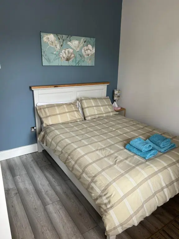 a bedroom with a bed with two blue towels on it at Rosebery apartment-Inverness in Inverness