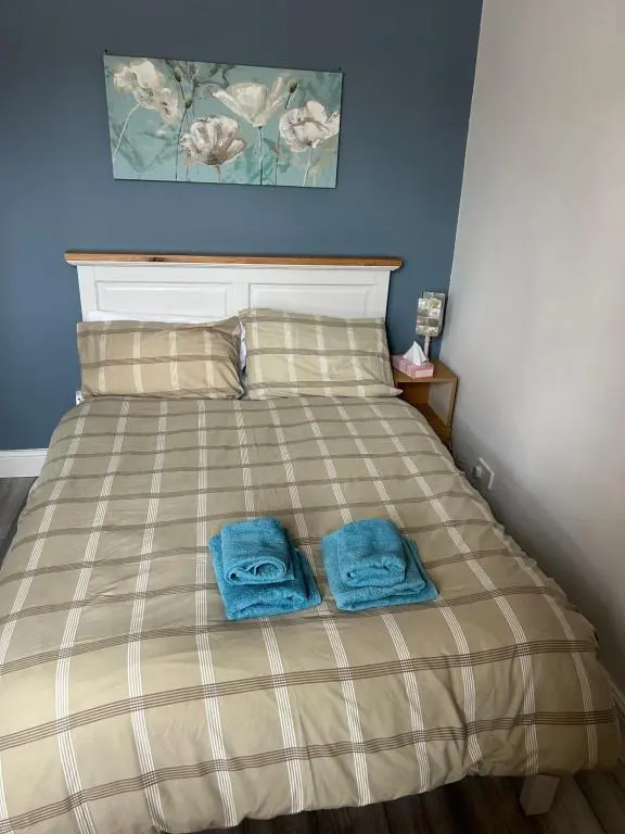 a bedroom with a bed with two towels on it at Rosebery apartment-Inverness in Inverness