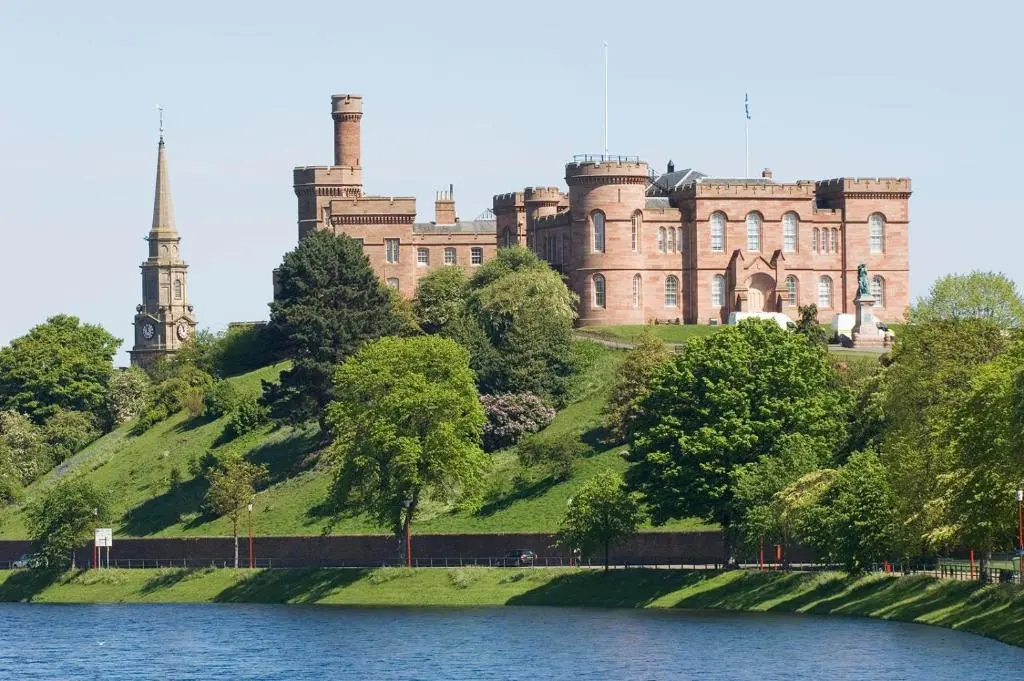 a castle on top of a hill next to a lake at Bonny Vista in Inverness