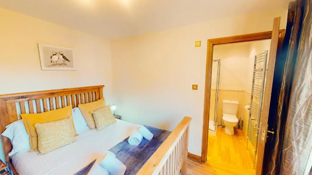 a bedroom with a bed and a bathroom with a toilet at The Shieling in Aviemore