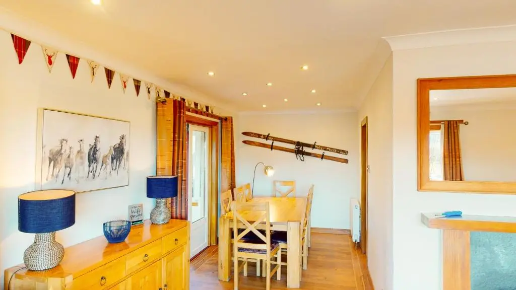a dining room with a table and a desk and a dining room at The Shieling in Aviemore